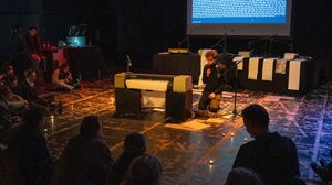 Photo of Tommi next to the pen plotter, performing The Metathinking Metamachine